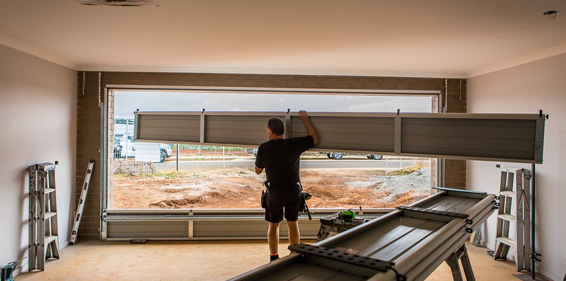Technician installing a large sectional garage door