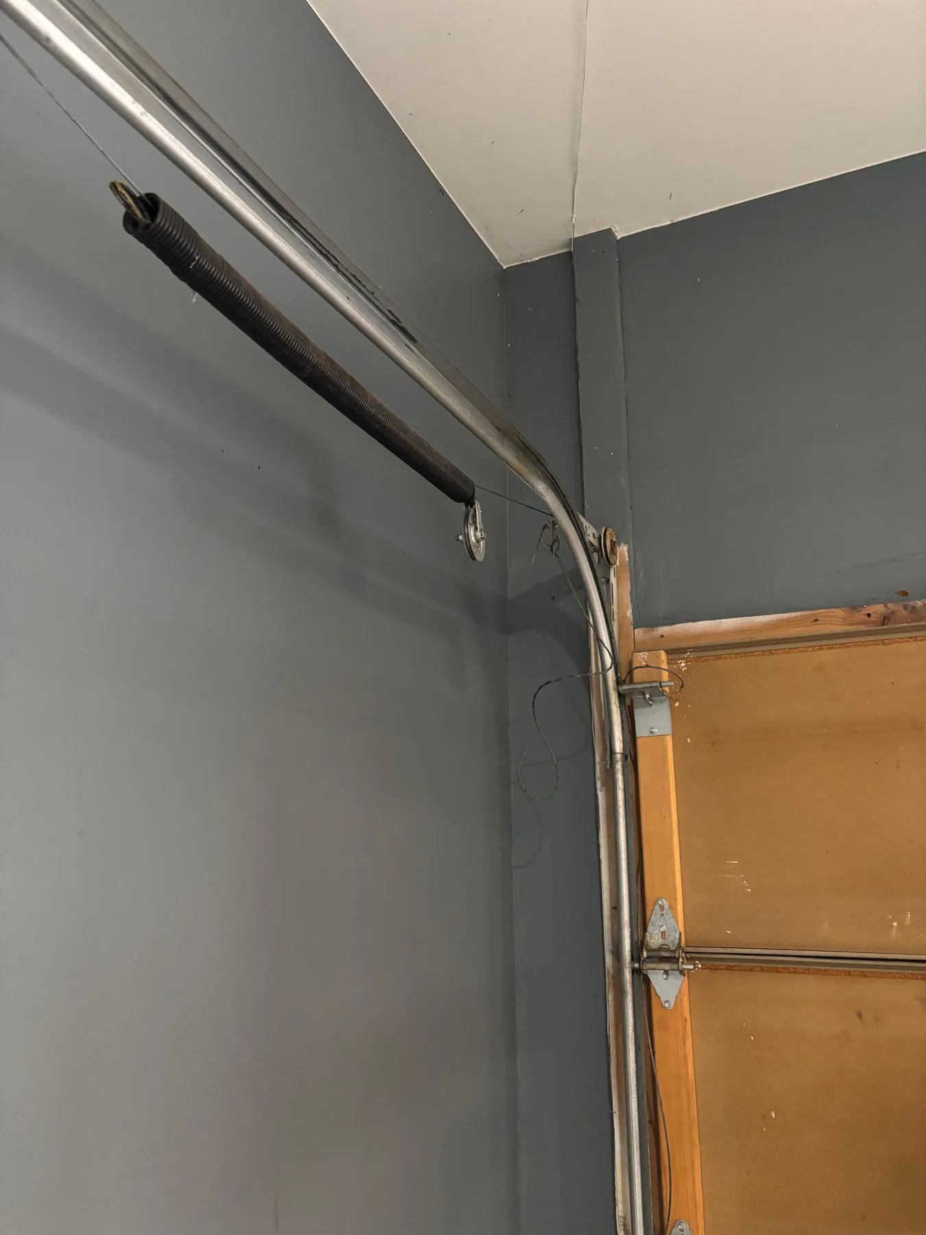 Broken extension spring on a Monument garage door before conversion in December 2025