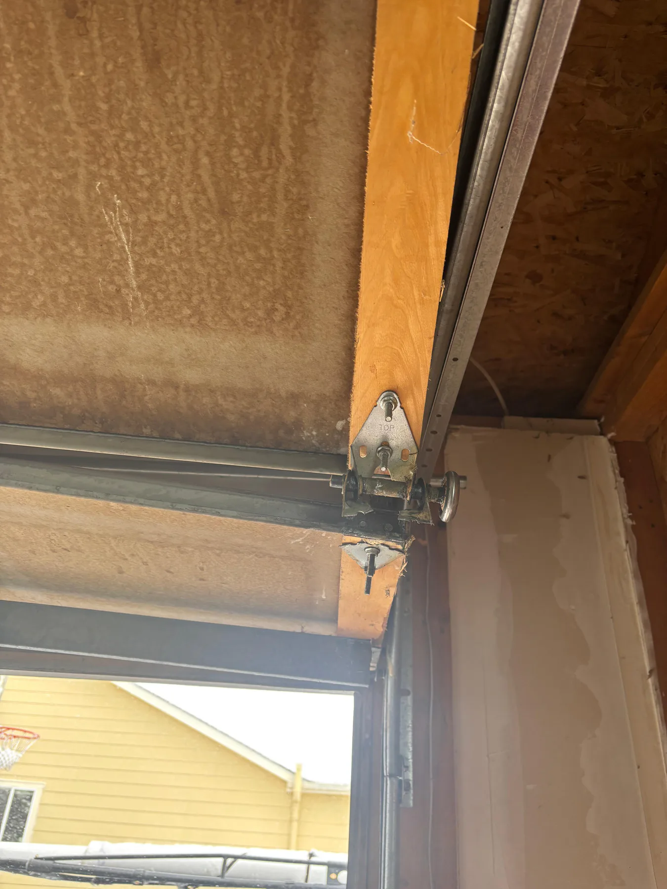 Wood garage door severely off track at a Security-Widefield home before replacement